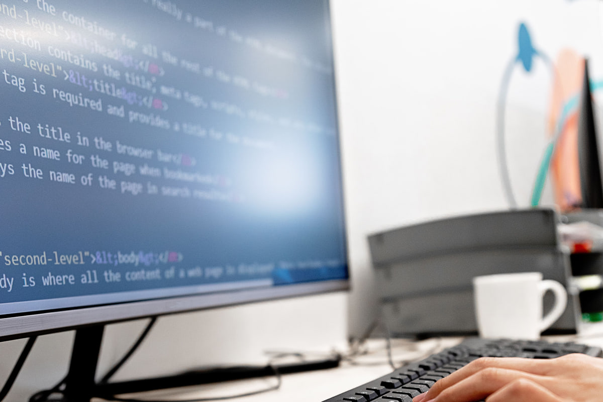 모니터에 HTML 코드를 띄워 두고 키보드를 치는 모습